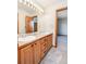 Bathroom featuring dual sinks and vanity with wood cabinets at 8316 Green Island Cir, Lone Tree, CO 80124