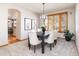 Elegant dining room with neutral tones, a modern chandelier, and plantation shutters at 8316 Green Island Cir, Lone Tree, CO 80124