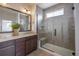 Bathroom featuring a tiled glass shower with a bench, double vanity, and a framed mirror at 15392 W 49Th Ave, Golden, CO 80403