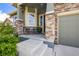 Inviting front porch with stone pillars and comfortable seating, perfect for relaxing outdoors at 15392 W 49Th Ave, Golden, CO 80403