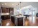 Modern kitchen with stainless steel appliances, dark cabinets, and a kitchen island overlooking dining area at 15392 W 49Th Ave, Golden, CO 80403