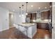 Stylish kitchen with a stainless steel vent hood, dark wood cabinets, and a large island with barstool seating at 15392 W 49Th Ave, Golden, CO 80403