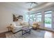 Bright living room with a sofa, patterned armchair, and a view of the outdoor patio through a glass door at 15392 W 49Th Ave, Golden, CO 80403