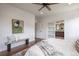Bright main bedroom with a ceiling fan, bench, and ensuite bathroom access at 15392 W 49Th Ave, Golden, CO 80403