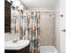 Bathroom with vanity, mirror, bathtub, and shower with colorful patterned curtain at 3202 S Dahlia St, Denver, CO 80222