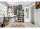 Bright bedroom features guitar, bookshelf, desk and chair, and large patterned rug at 3202 S Dahlia St, Denver, CO 80222