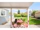 Charming covered patio with a red table set, perfect for outdoor dining and enjoying the backyard view at 3202 S Dahlia St, Denver, CO 80222