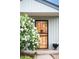 Close-up of the front door featuring a decorative screen door and a small flower arrangement on the porch at 3202 S Dahlia St, Denver, CO 80222