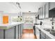 Modern kitchen with gray cabinets, white countertops, and hardwood floors, adjacent to the living area at 3202 S Dahlia St, Denver, CO 80222
