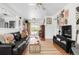 Bright living room with hardwood floors, a comfortable black sofa, and access to the backyard at 3202 S Dahlia St, Denver, CO 80222