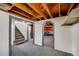 View of the basement with an exposed wooden ceiling and gray carpeting at 2226 Fulton St, Aurora, CO 80010