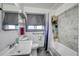 Bright bathroom featuring gray tiling, a white sink, and a window with privacy shades at 2226 Fulton St, Aurora, CO 80010