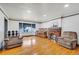 Bright living room featuring a brick fireplace, hardwood floors, a piano, and lots of space at 2226 Fulton St, Aurora, CO 80010