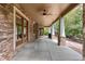 Covered back porch with stone pillars, ceiling fan, and a view of the private backyard at 1313 Jade Ln, Longmont, CO 80504
