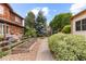 Serene backyard featuring raised garden beds, a winding walkway, lush greenery, and a playset at 1313 Jade Ln, Longmont, CO 80504