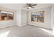 Bedroom featuring soft carpet flooring, a ceiling fan, and two large windows overlooking the surrounding landscape at 1313 Jade Ln, Longmont, CO 80504