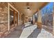 Spacious covered patio featuring stone accents, ceiling fan, and access to the home's interior at 1313 Jade Ln, Longmont, CO 80504