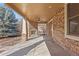 Inviting covered patio with stone fireplace and ceiling fan, great for outdoor relaxation and entertaining at 1313 Jade Ln, Longmont, CO 80504