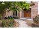 Inviting front entrance featuring a beautiful wood door, stone archway, and cozy seating area at 1313 Jade Ln, Longmont, CO 80504
