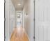 Hallway with hardwood floors and white trim leading to a bathroom at 1313 Jade Ln, Longmont, CO 80504