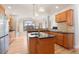 Open kitchen with wood cabinets, granite counters, island sink, hardwood floors and natural light at 1313 Jade Ln, Longmont, CO 80504