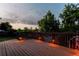 Picturesque wooden deck with built-in lighting and views of the lush backyard at 16291 E 7Th Dr, Aurora, CO 80011