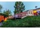 Backyard view showcasing lush green lawn with an upper deck and covered hot tub feature at 16291 E 7Th Dr, Aurora, CO 80011