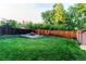 Spacious backyard featuring a lush green lawn, privacy fence, and fire pit, perfect for outdoor gatherings at 16291 E 7Th Dr, Aurora, CO 80011