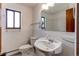 Bright bathroom with white tile, a pedestal sink, and a window at 16291 E 7Th Dr, Aurora, CO 80011