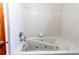 Bathroom featuring a soaking tub with jets, white tiling, and a shower head at 16291 E 7Th Dr, Aurora, CO 80011