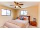 Comfortable bedroom with two windows, ceiling fan, and a nicely appointed bed at 16291 E 7Th Dr, Aurora, CO 80011