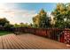 Large wooden deck overlooking the backyard, featuring a charming red barn-style shed at 16291 E 7Th Dr, Aurora, CO 80011