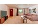 Bright living room with a red front door, large window, neutral carpet, and comfortable sectional sofa at 16291 E 7Th Dr, Aurora, CO 80011