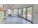Bright sunroom with tile flooring, fireplace, and access to a wooden deck at 16291 E 7Th Dr, Aurora, CO 80011