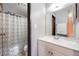 A clean bathroom with a white vanity, mirror, and a shower with patterned curtain at 7770 W 38Th Ave # 207, Wheat Ridge, CO 80033