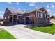 Inviting home featuring a stone and siding exterior, well-manicured lawn, and a paved driveway leading to a two-car garage at 12820 Inca St, Westminster, CO 80234