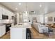 Open concept kitchen with a marble island, white cabinets, stainless appliances, and a seamless view into the living area at 12820 Inca St, Westminster, CO 80234