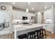 Bright kitchen featuring white cabinets, a large island with bar seating, and stainless steel appliances at 12820 Inca St, Westminster, CO 80234
