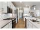 Modern kitchen showcasing stainless steel appliances, subway tile backsplash, and flowing seamlessly into the living space at 12820 Inca St, Westminster, CO 80234