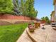 Expansive backyard with a retaining wall, lush grass, and a stone patio perfect for outdoor entertaining at 2544 S Fundy Cir, Aurora, CO 80013