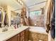 Bathroom with a double sink vanity with marble countertops and tiled backsplash and shower at 2544 S Fundy Cir, Aurora, CO 80013