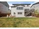 Large backyard with grass, patio, and two-story home with deck and exterior stairs at 11046 Pastel Pt, Parker, CO 80134