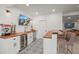 Basement bar with wood countertops, mini-fridge, white cabinets, and adjacent bar seating at 11046 Pastel Pt, Parker, CO 80134