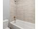 Bright bathroom with beige tiles surrounding the tub and shower combo at 11046 Pastel Pt, Parker, CO 80134