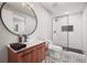 Modern bathroom with wood vanity, striking tile floor, and walk-in shower with hexagon tile at 11046 Pastel Pt, Parker, CO 80134