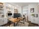 Bright home office featuring custom built-ins, a desk, and hardwood floors at 11046 Pastel Pt, Parker, CO 80134