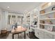 Well-lit home office with custom built-ins, desk, and large windows at 11046 Pastel Pt, Parker, CO 80134