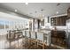 Modern kitchen featuring a large island with seating, stainless steel appliances, and stylish pendant lighting at 11046 Pastel Pt, Parker, CO 80134