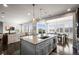 Open kitchen featuring a granite island with seating, pendant lighting, and a view of the living area at 11046 Pastel Pt, Parker, CO 80134