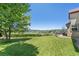 Expansive backyard featuring a well-manicured lawn, mature trees, and a view of distant mountains at 4099 Starflower Rd, Castle Rock, CO 80109